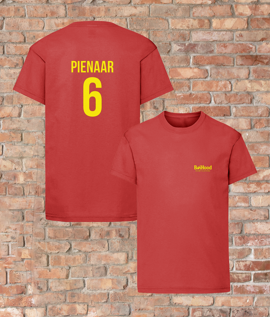 BoiHood Kids Unisex T-Shirt featuring 'Pienaar 6' on the back against a brick wall backdrop.